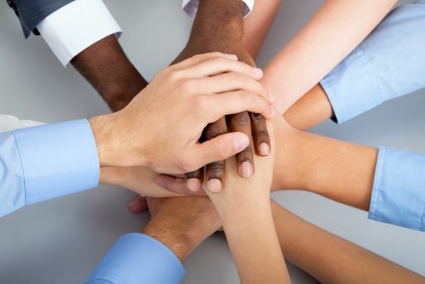 Diverse group of hands all connected looking united
